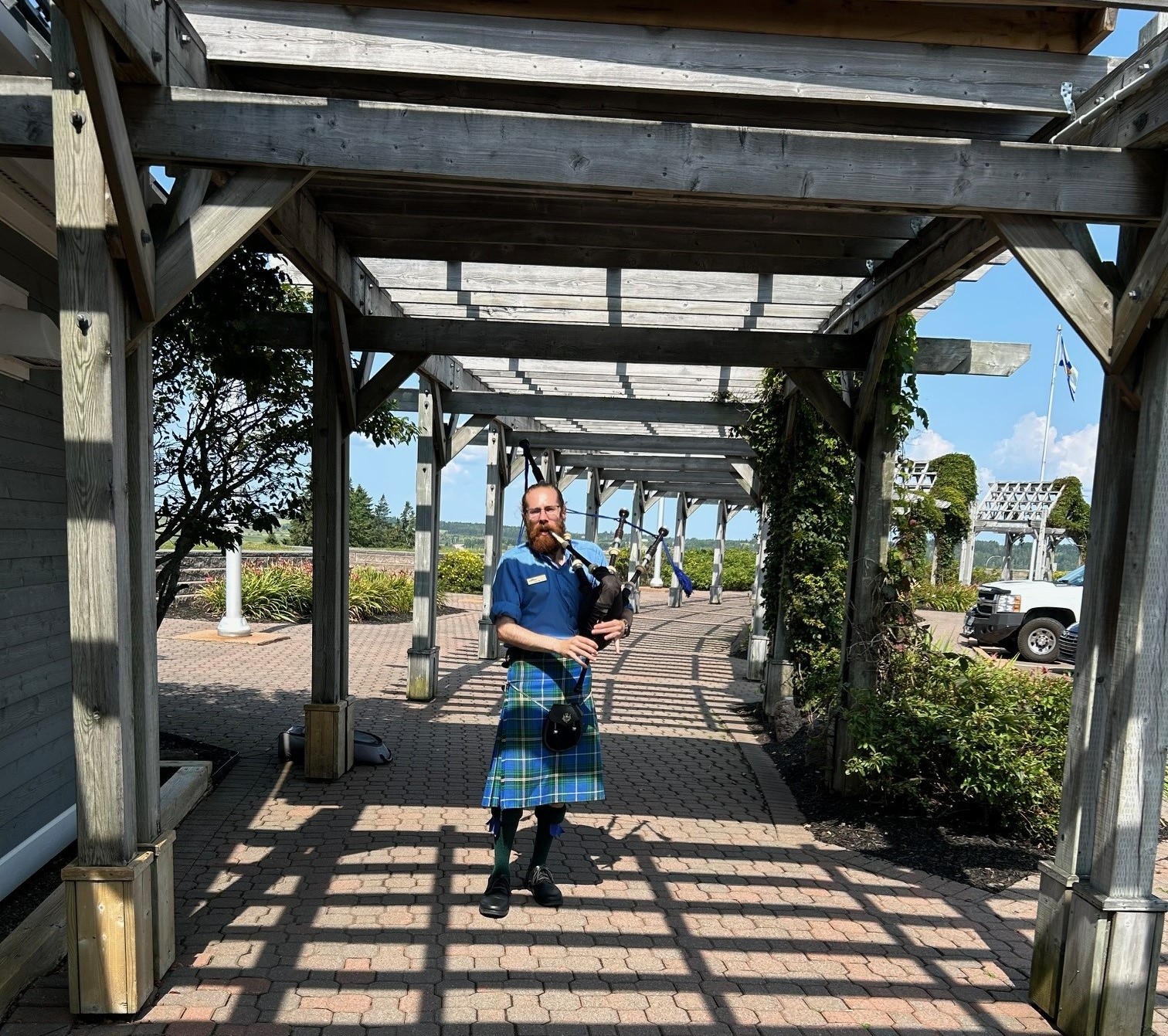 A man standing outside playing the bagpipes 