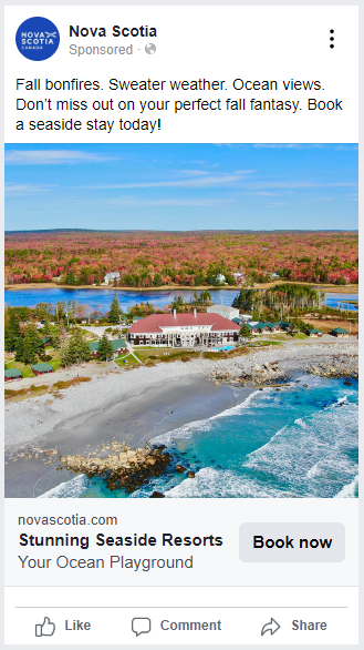 A hotel located beside a beach with a lake and trees in the background