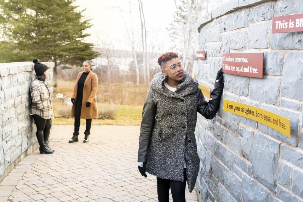 Woman looking at panels on outdoor display at Black Loyalist Heritage Cetnre.