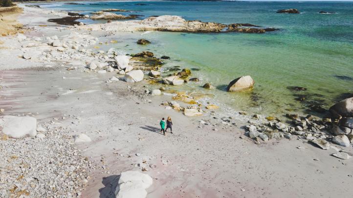 Two people walking along the beach 