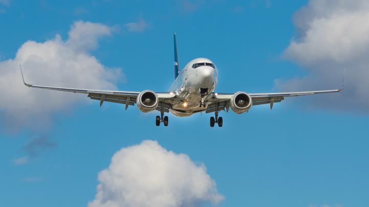 An airplane in the sky with the landing gear ready 