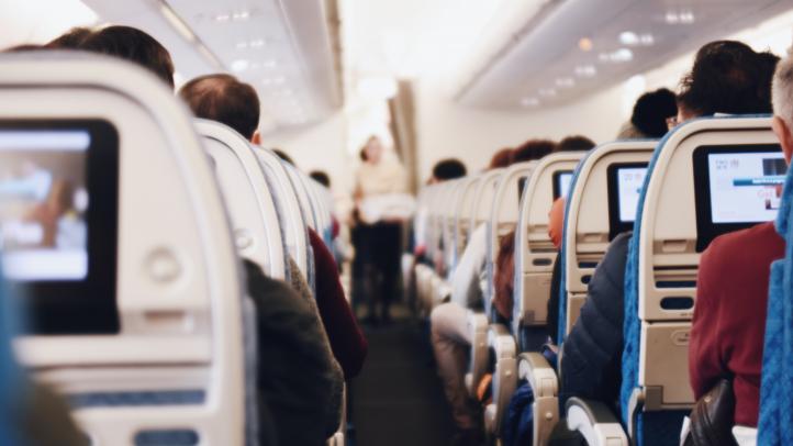 View from standing at the back of an airplane looking up the aisle to the front of the plane